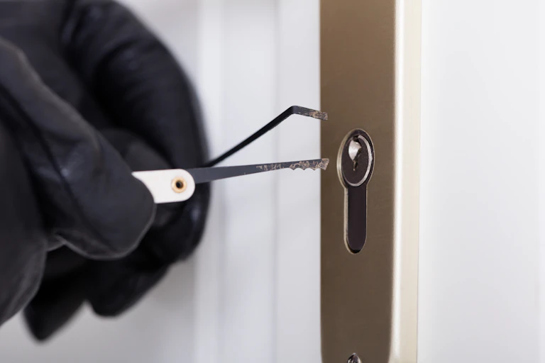 Gloved hand picking a lock