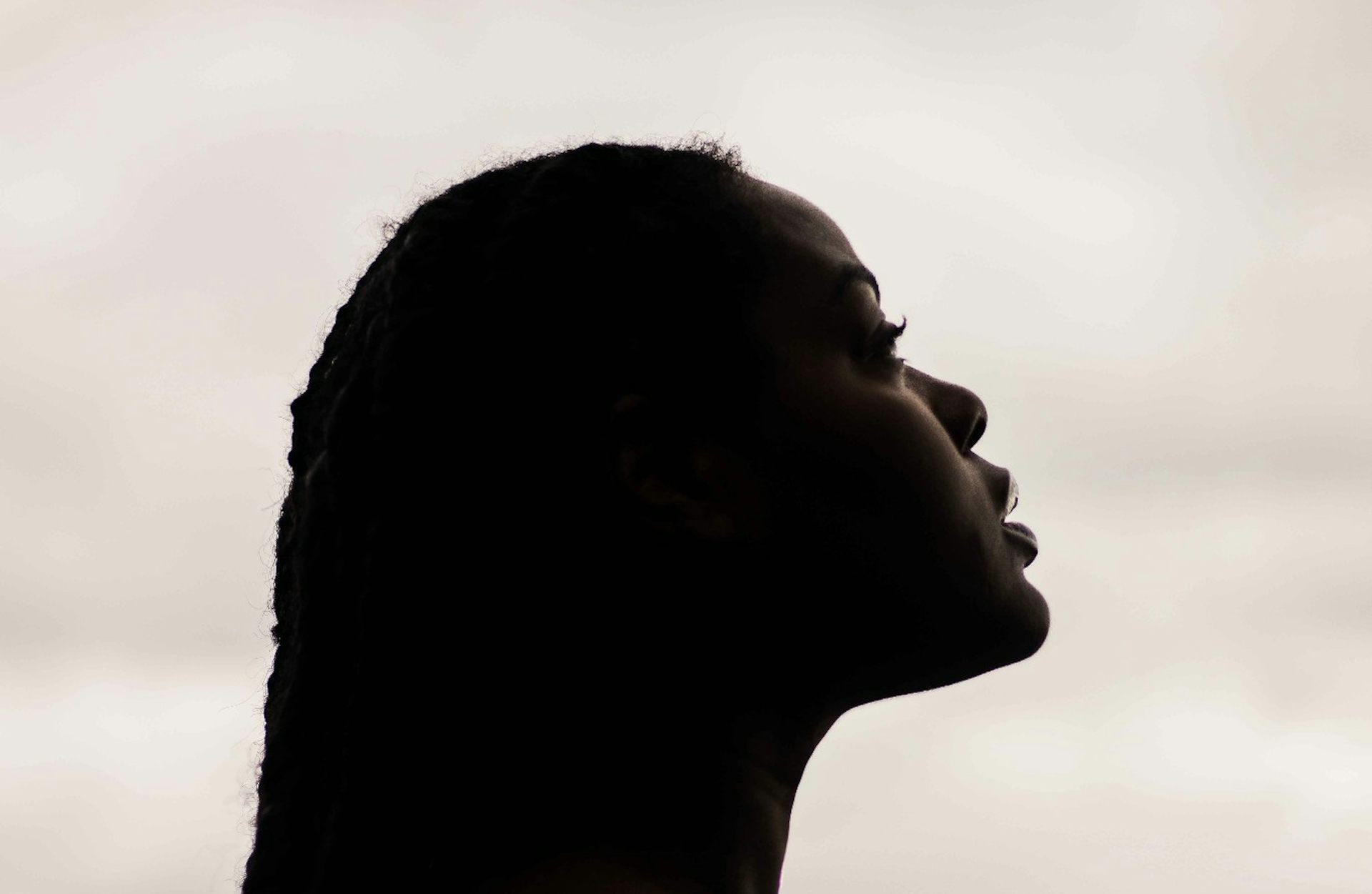 A profile of a Black woman looking slightly upwards.