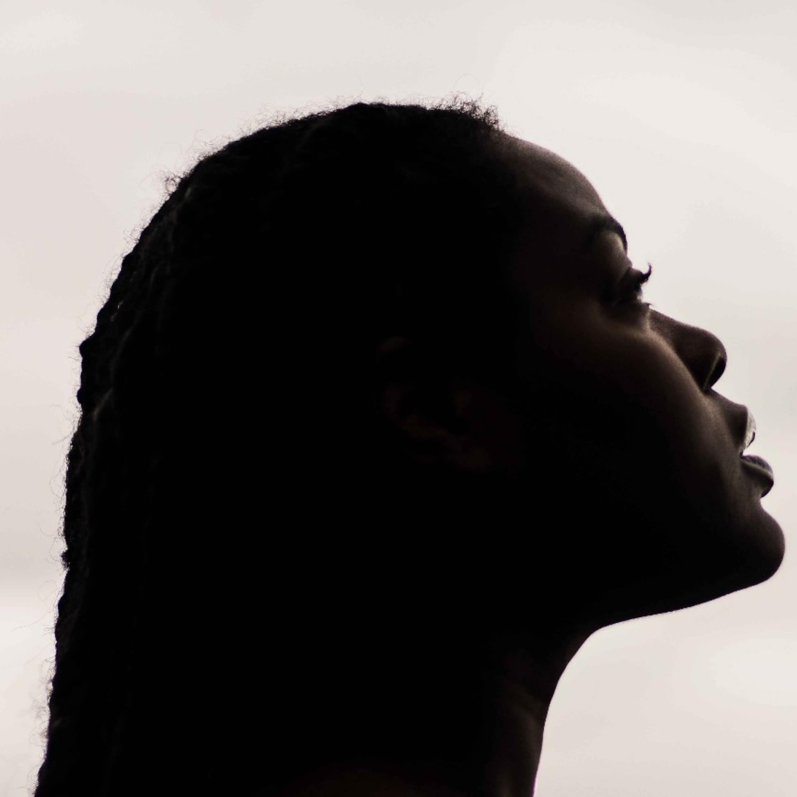 A profile of a Black woman looking slightly upwards.