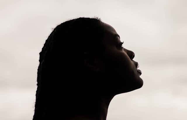 A profile of a Black woman looking slightly upwards.
