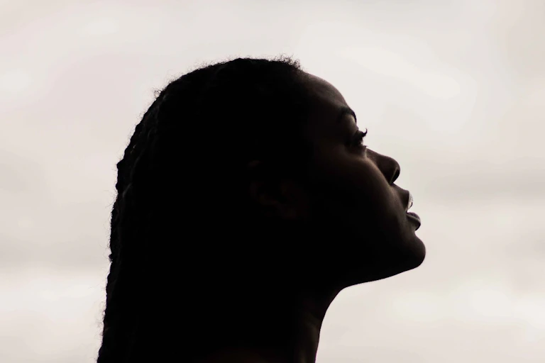 A profile of a Black woman looking slightly upwards.