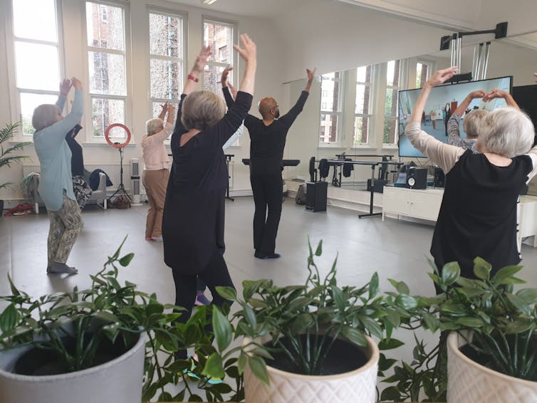 People dancing in front of a screen