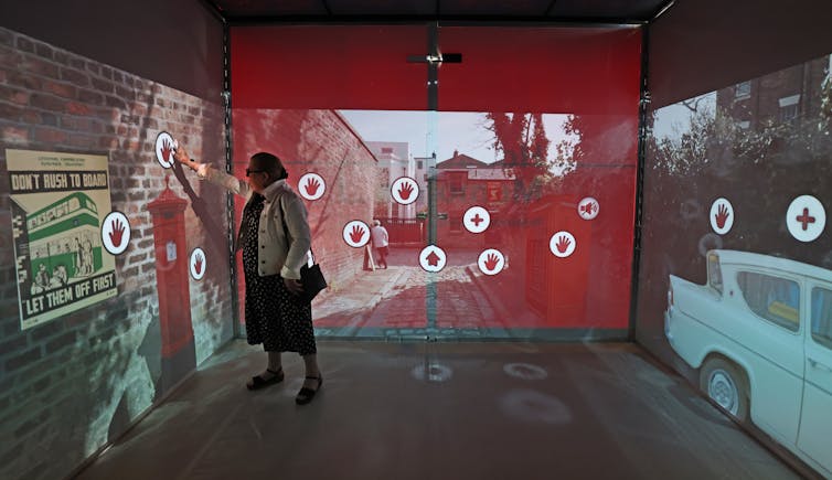 Person pressing touchpad in interactive exhibit