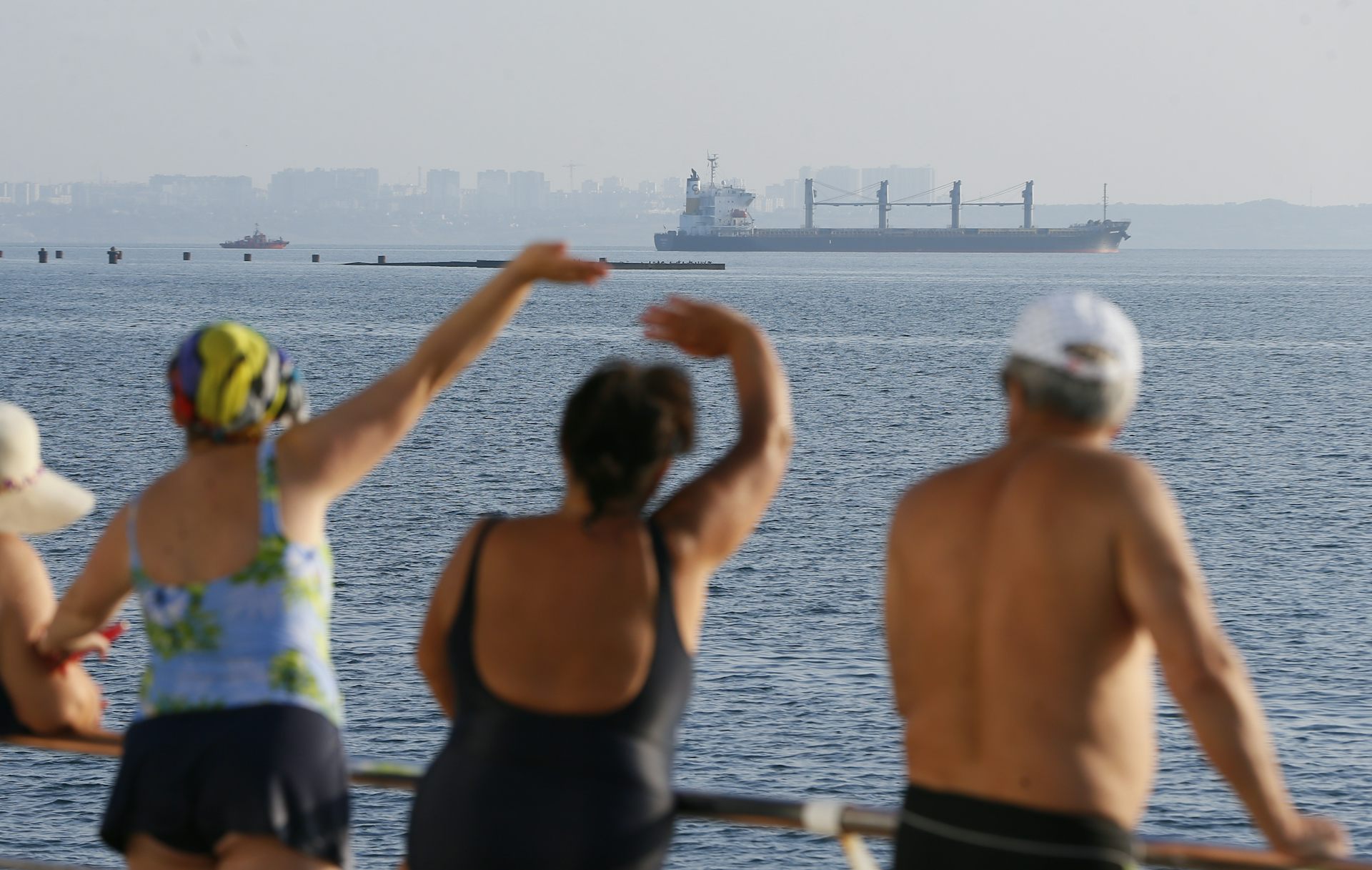 People watch cargo vessel Navi Star carrying 33,000 tonnes of corn to Ireland leave the port of Odesa, Ukraine, 05 August 2022.