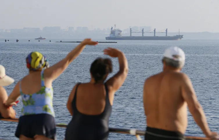 People watch cargo vessel Navi Star carrying 33,000 tonnes of corn to Ireland leave the port of Odesa, Ukraine, 05 August 2022.