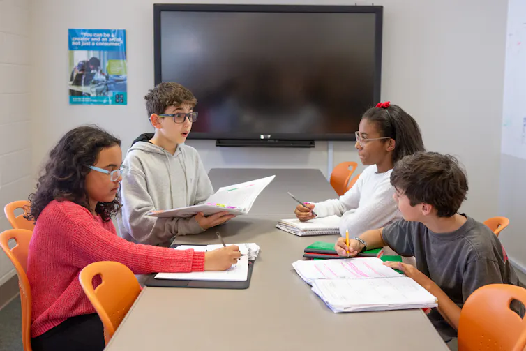 Students seen working at a table.