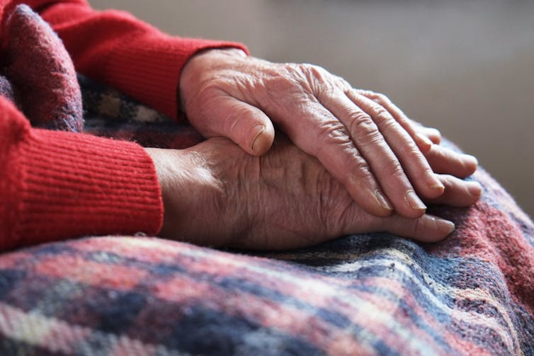 elderly woman folds hands