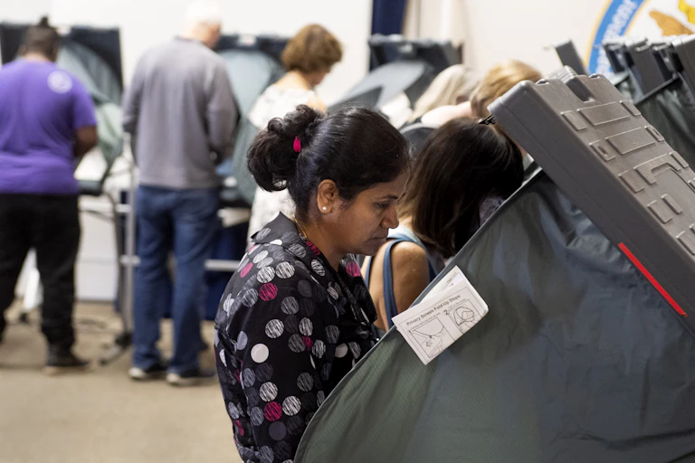 People stand at voting stations