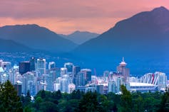 Vancouver skyline at sunset with the silhouette of the mountains in the background.