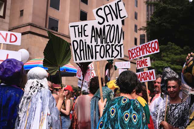 People carrying signs calling for the Amazon rainforest to be saved