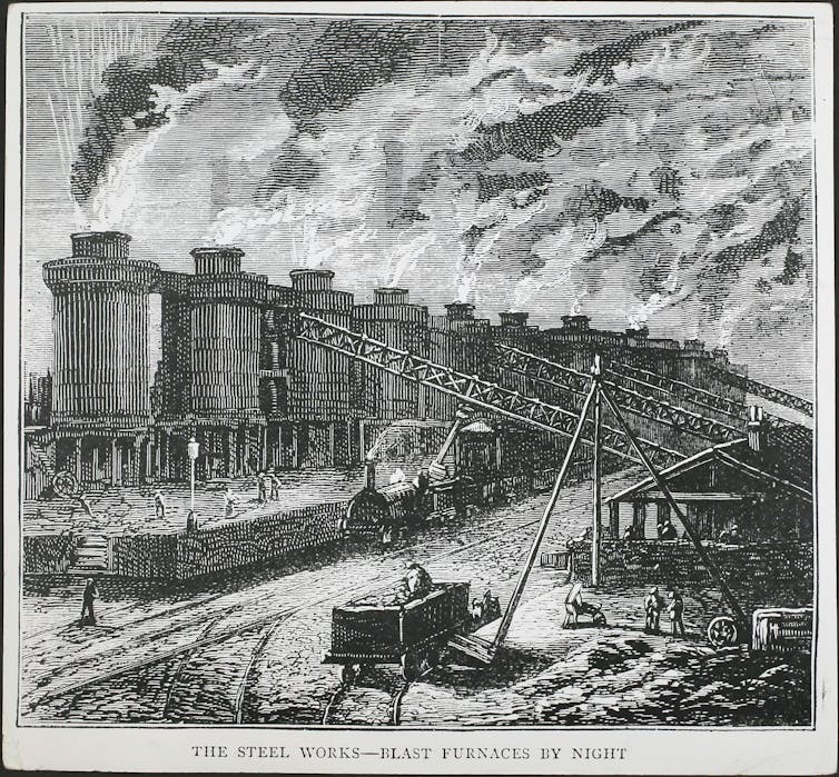 An illustration of a row of giant ovens with steam coming out, wagons carrying coal and a locomotive, with workers rushing through.
