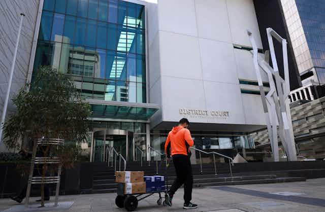 A man walks in front of a District Court in Perth.