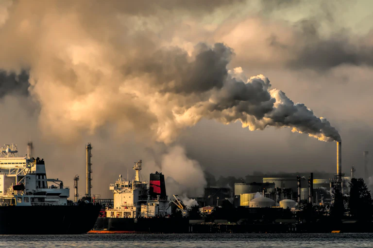Operating fossil fuel plant behind cargo ships
