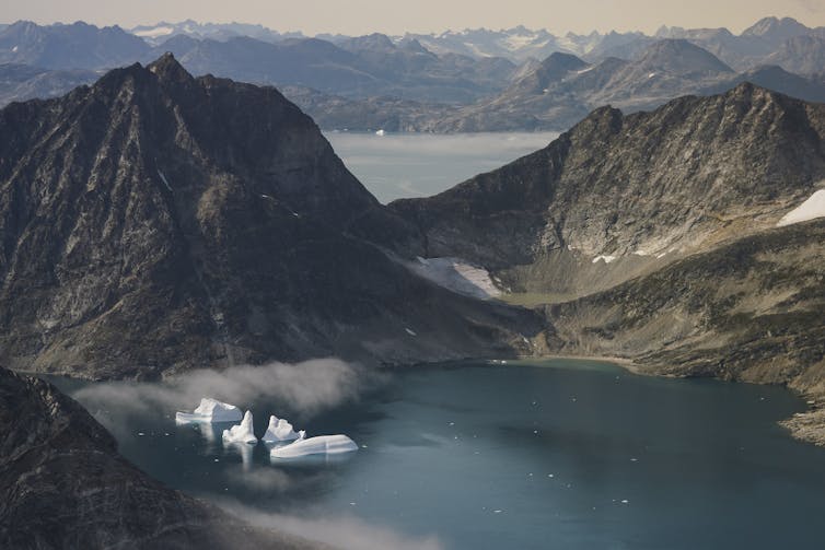 Iceberg nell'oceano vicino a una valle