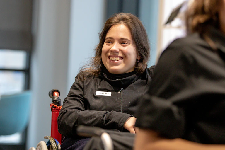 woman smiles, uses wheelchair