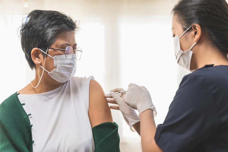 A woman receives a vaccination.