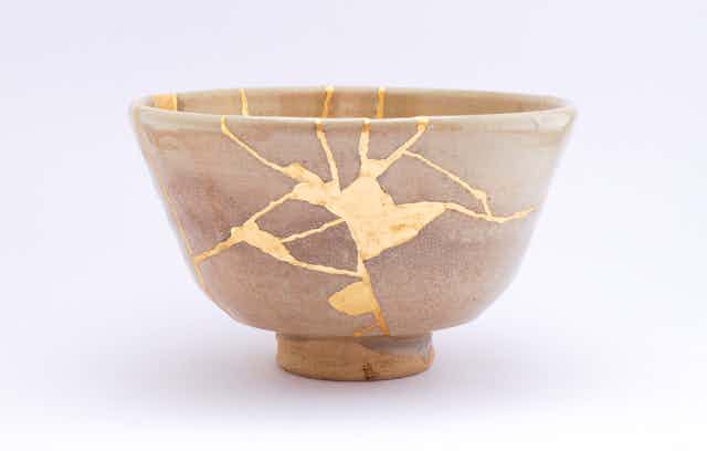 A broken bowl has been put back together with gold glue.