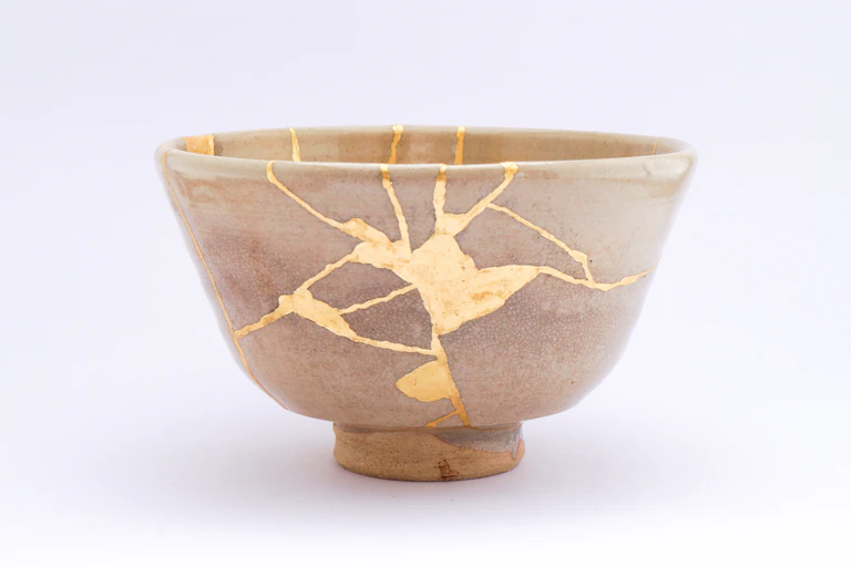 A broken bowl has been put back together with gold glue.