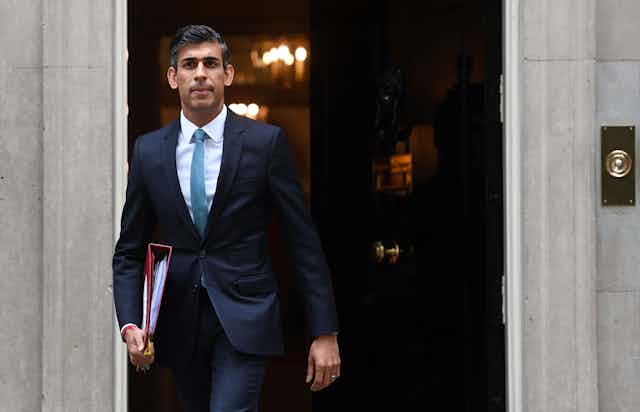 Rishi Sunak walking out of Number 10 with a binder under his arm