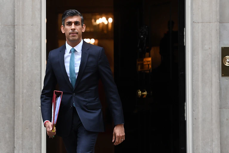 Rishi Sunak walking out of Number 10 with a binder under his arm