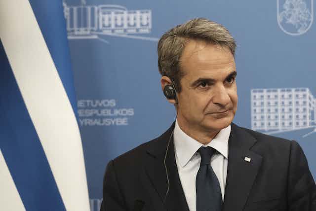 Kyriakos Mitsotakis wearing an earpiece at a press conference