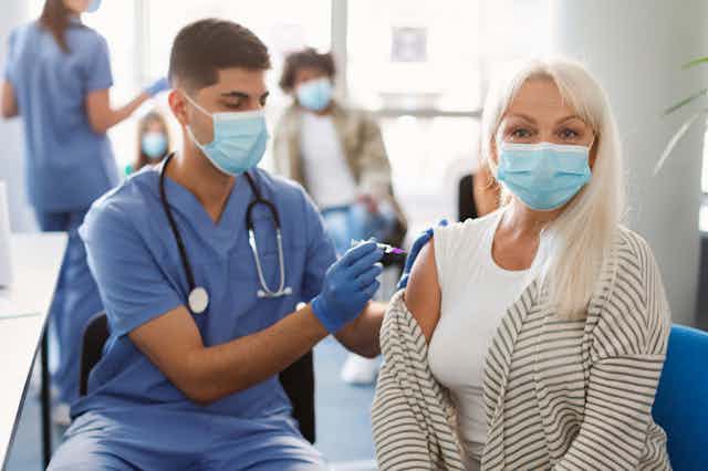 A woman receives a vaccination.