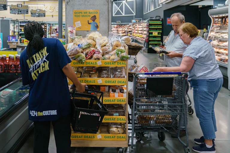 A middle-aged couple are shopping in a grocery store.