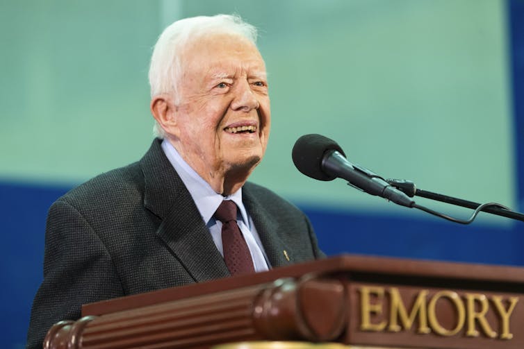 Jimmy Carter stands on a podium