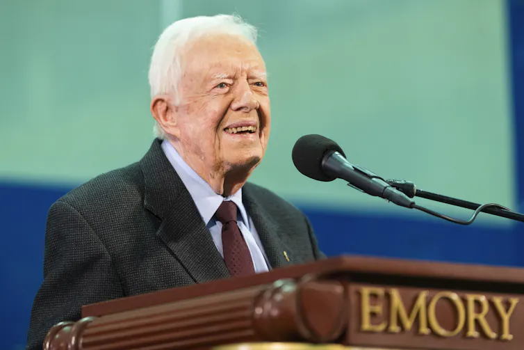 Jimmy Carter stands at a podium