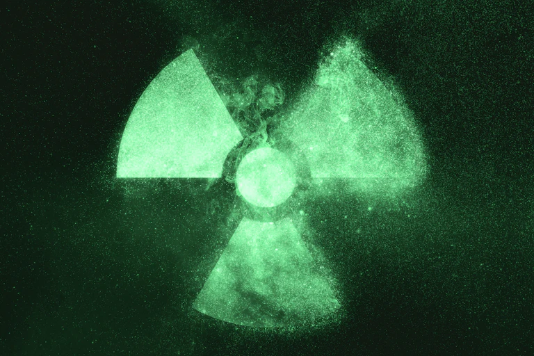 A radiation symbol glowing faintly green on a dark background