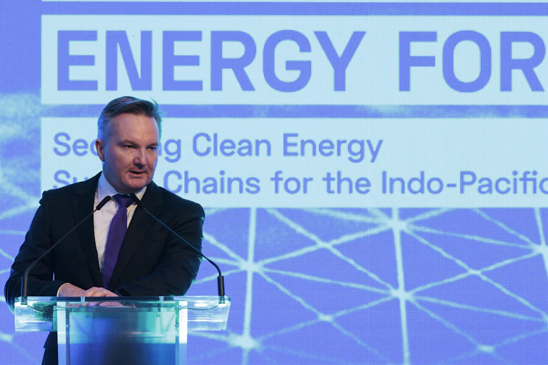 Man in suit speaking at podium at an energy forum