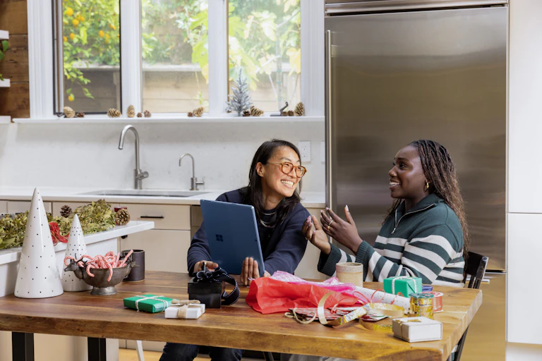 Two women sitting at a desk looking at an iPad