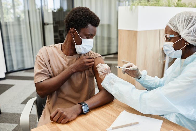 A young man receives a vaccination.