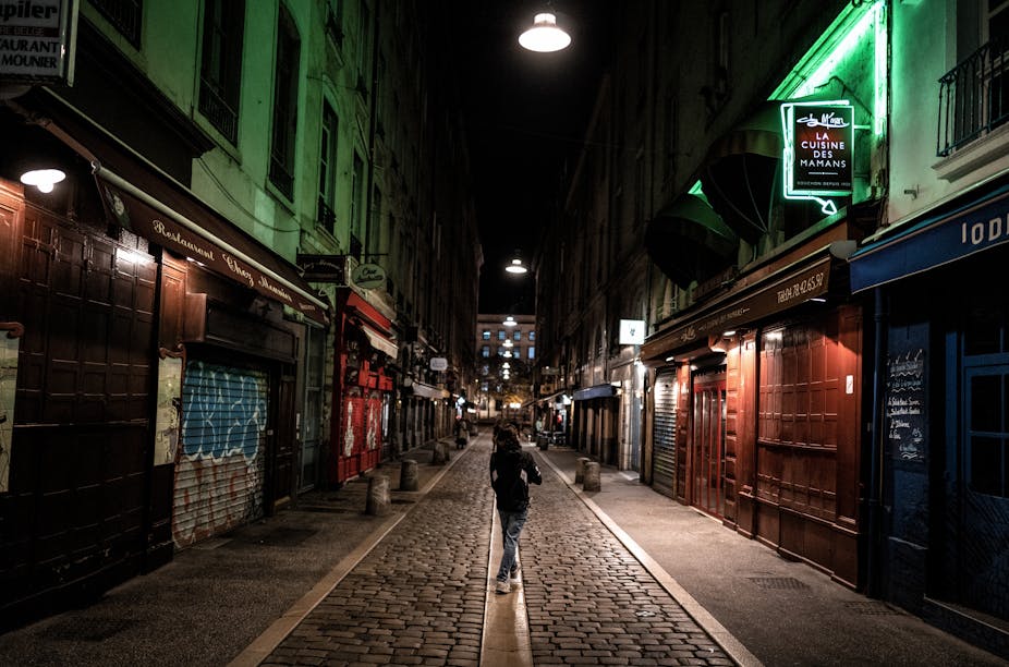 Un homme marche dans la rue déserte des Marronniers à Lyon le 17 octobre 2020