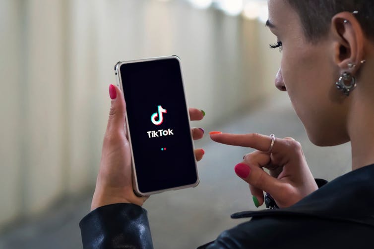 Younger person accessing Tik Tok on phone.
