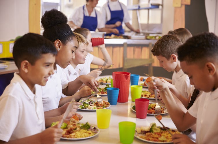 Children eating lunch at a cafeteria table.