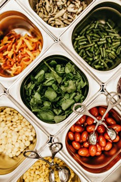 Salad bar vegetables including beans, spinach, tomato and corn.