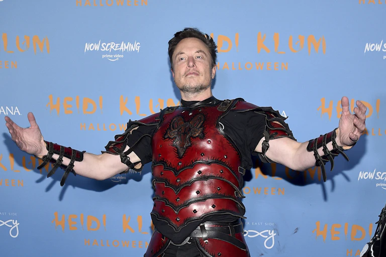 Elon Musk in costume, posing on the red carpet for Heidi Klum's birthday party.