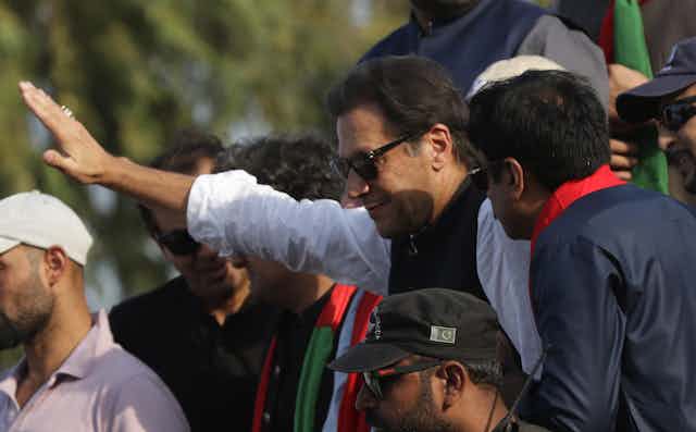 Imran Khan gesturing while surrounded by colleagues
