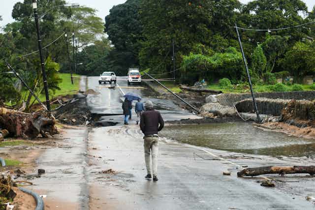 A man walking down a flood-damaged road