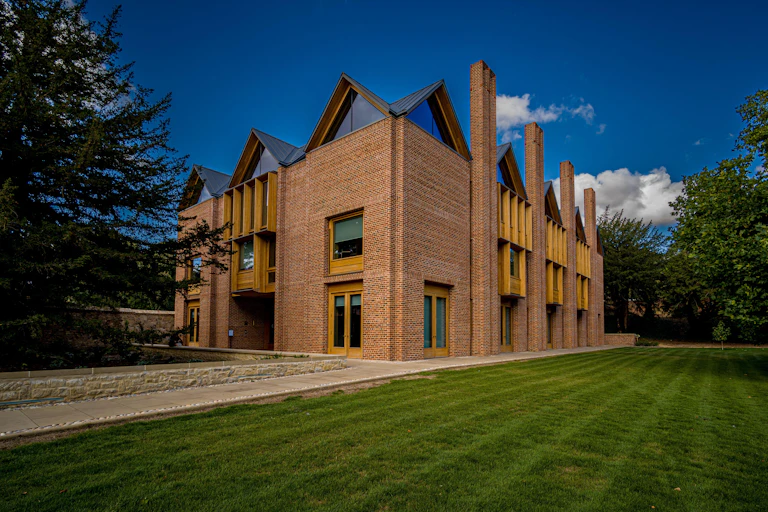 A red brick building with gabled windows under a blue sky.
