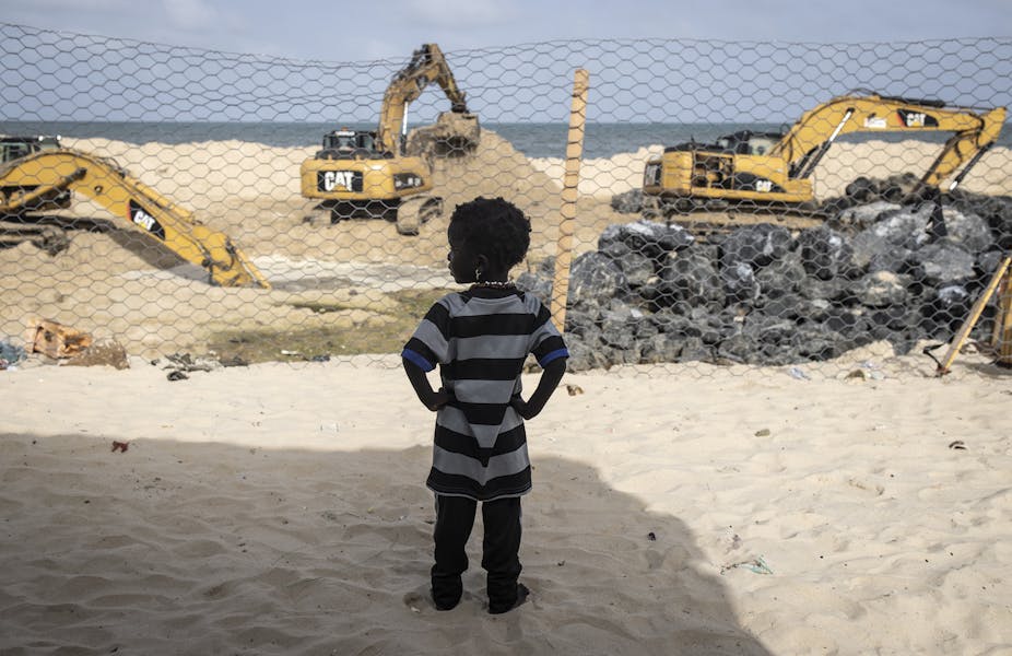 Une petite Sénégalaise observant la construction d’une digue