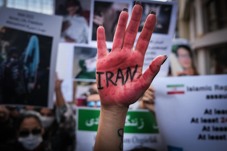 Iranian people hold pictures of Mahsa Amini with their hands painted in red during a protest outside the Iranian Consulate in Istanbul, October 2022.