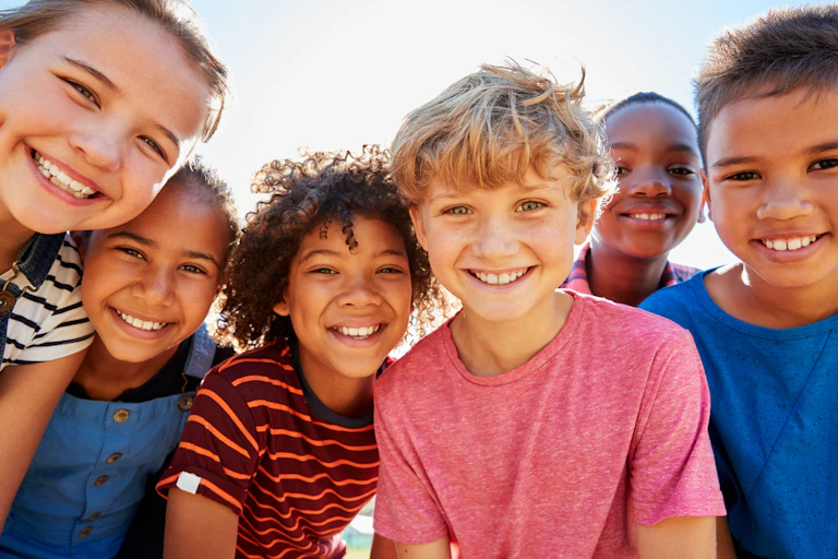A group of six children of preteen age smiling into the camera