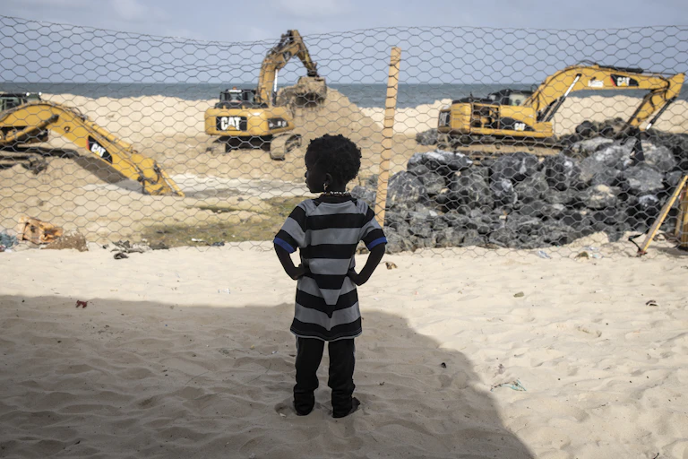 A Senegalese girl watching the construction of a dam