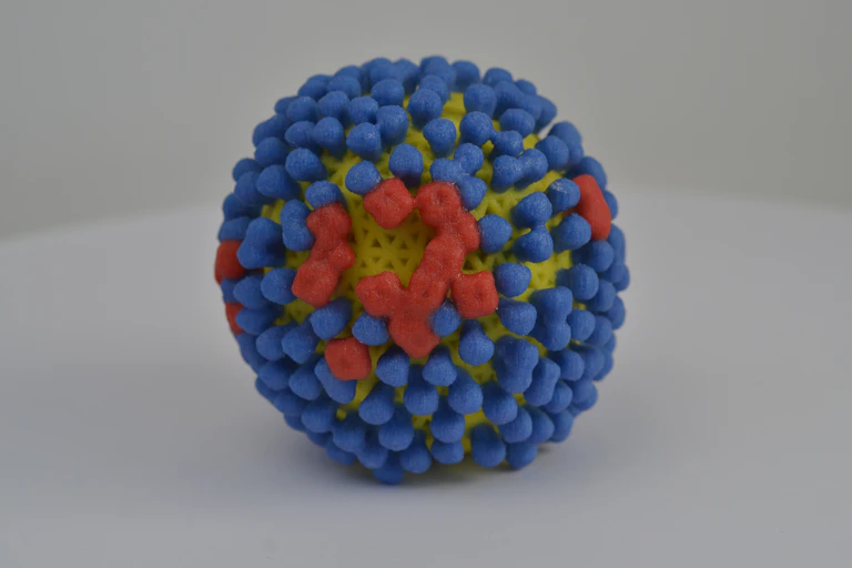 A round model with mostly blue studs and few red studs against a yellow surface.