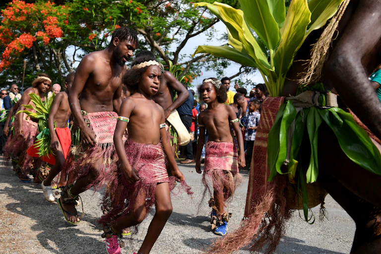 adults and children dance in traditional dress