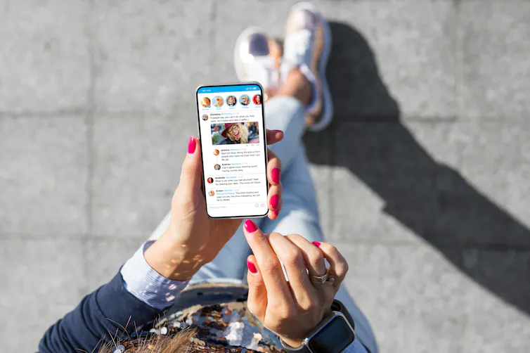 A woman scrolling through her Twitter feed on her phone.