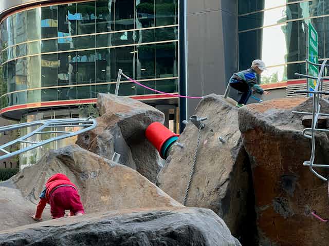 Kids climb over boulders