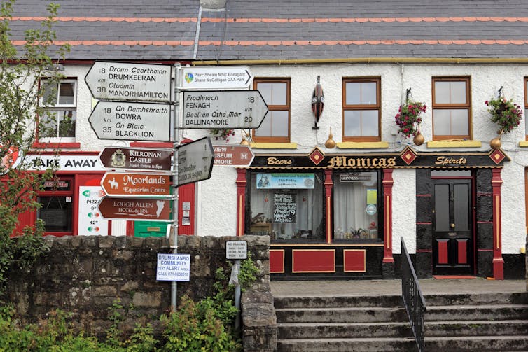 Un indicator rutier cu multe destinații în fața unui pub din Drumshanbo din Leitrim, Irlanda.